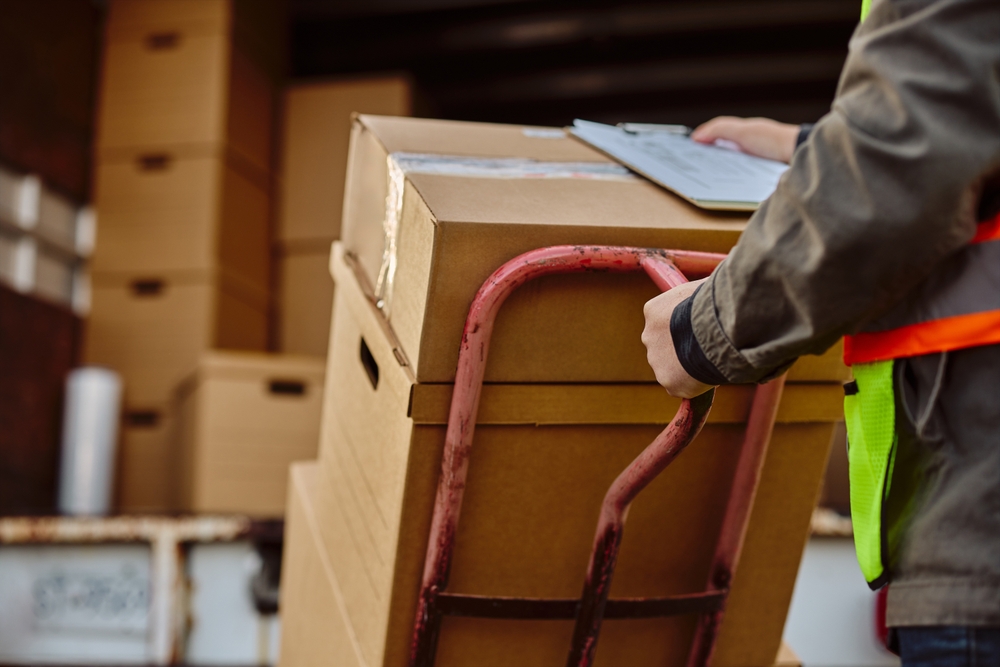 Close,Up,Of,Deliverer,Unloading,Cardboard,Boxes,Out,Of,A