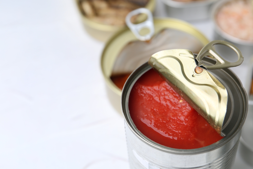Open,Tin,Cans,With,Different,Preserved,Products,On,White,Table,