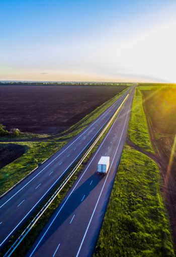 White,Trailer,Car,Driving,On,Asphalt,Road,On,The,Sunset